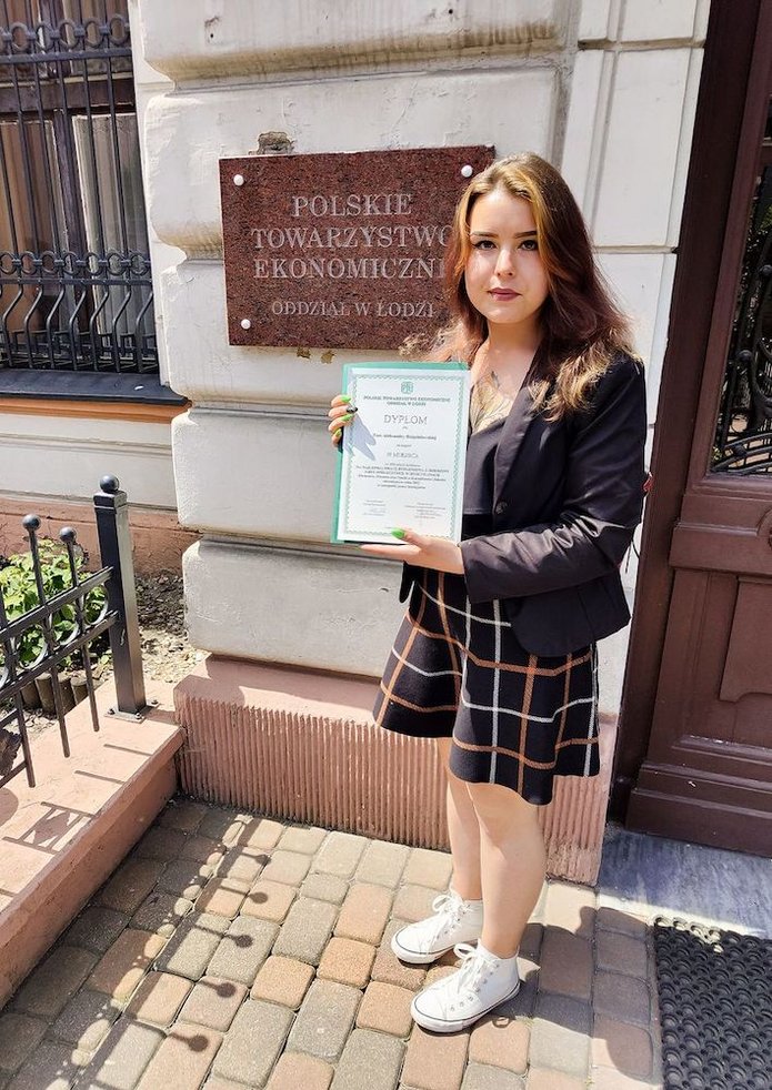 osoba trzymająca w rękach dyplom